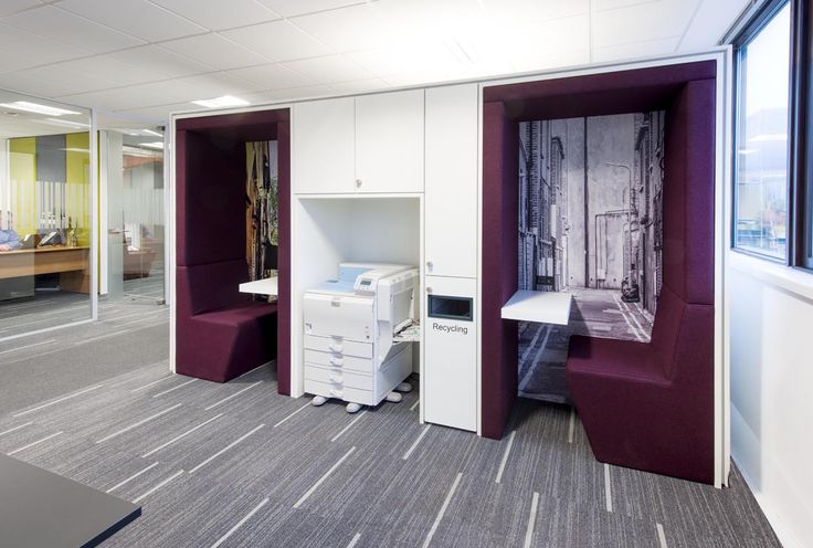 an office cubicle with purple walls and white furniture in the center, including a printer