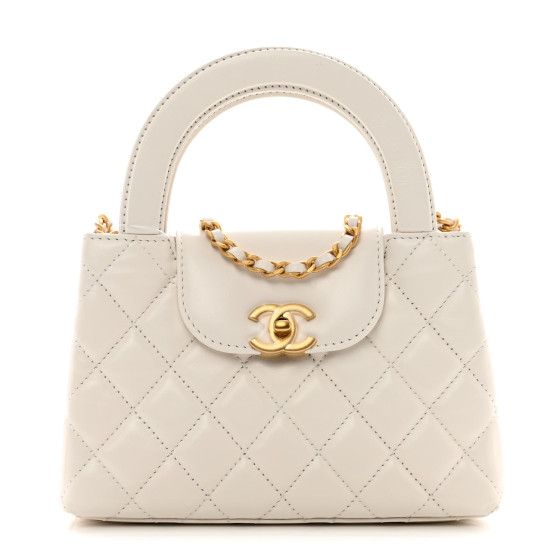 This is an authentic CHANEL Shiny Aged Calfskin Quilted Nano Kelly Shopper in White. This chic mini bag is crafted of quilted calfskin leather in white. The bag features rolled top handles, a gold chain leather threaded shoulder strap, and a crossover strap with a gold CC turn lock. This opens to a white leather interior with zipper and patch pockets. White Chanel Bag, Chanel Crossbody, Oversized Bag, Kelly Bag, White Purses, Versace Bags, Leather Thread, Leather Chain, Handle Bag