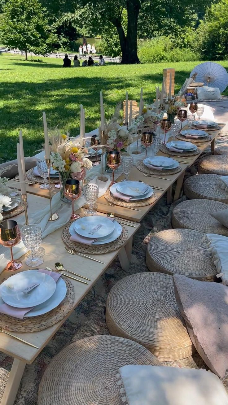 an outdoor table set with place settings and plates