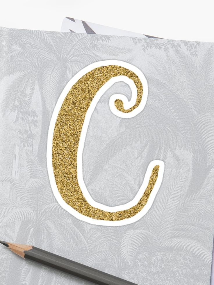 the letter c is made out of gold glitter and has a pencil in front of it