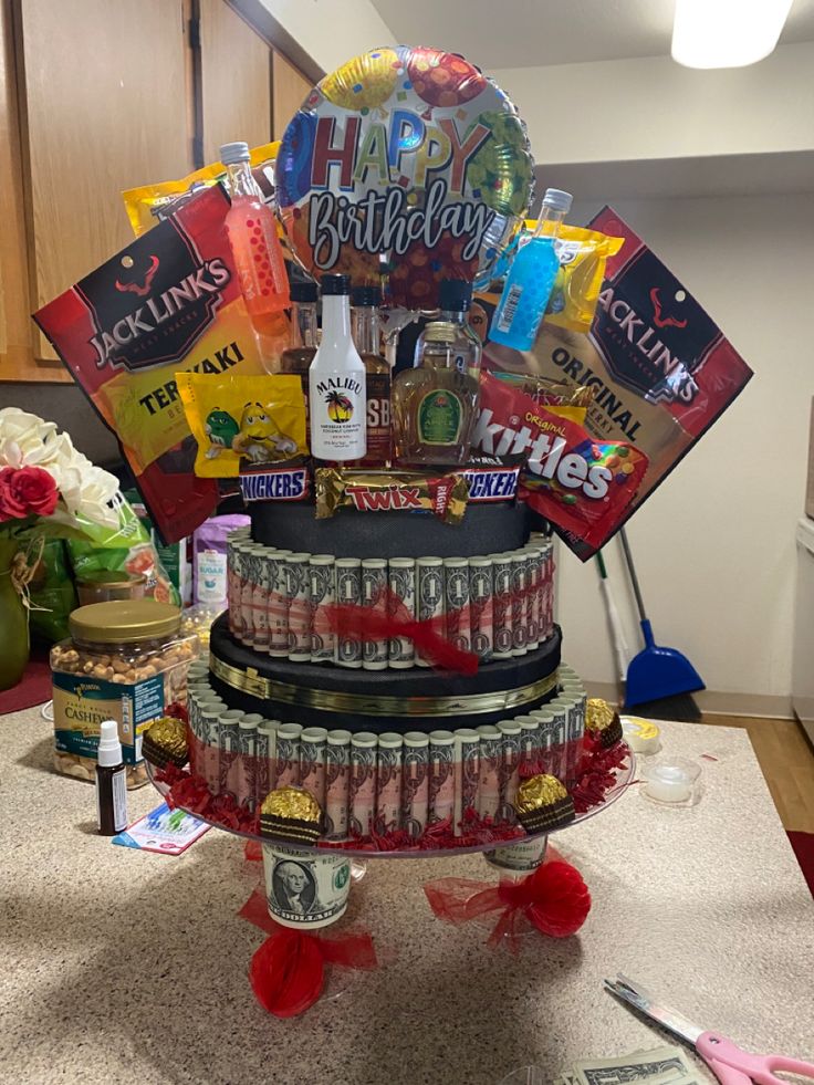 a birthday cake with lots of candy and candies on the top, sitting on a kitchen counter