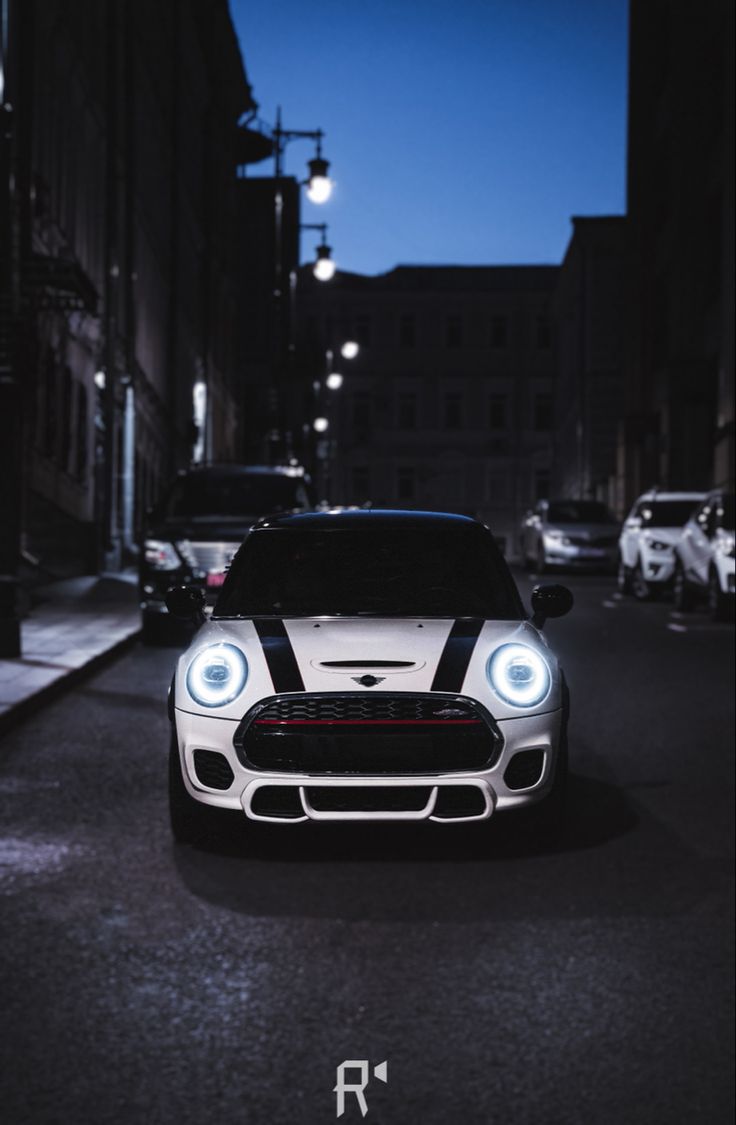 a white and black car parked on the side of a road in front of some buildings