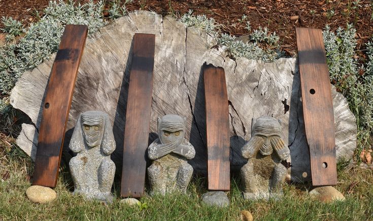 three wooden skis sitting next to each other in front of a stone wall and grass