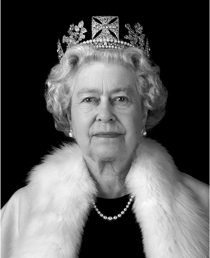 an older woman wearing a tiara and fur stole around her neck, looking at the camera