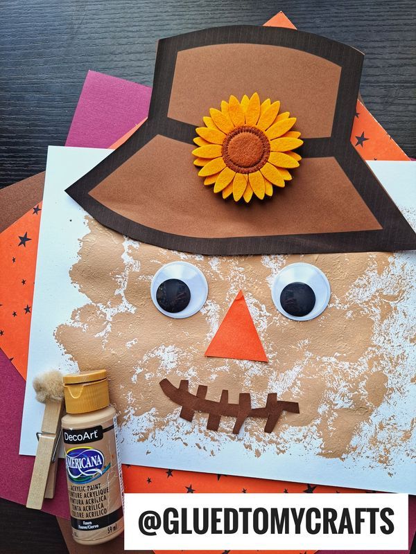 a paper plate with a scarecrow and sunflower on it, next to glue paint