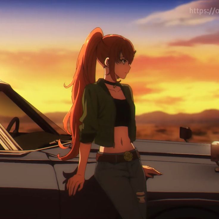 a woman standing next to a car in front of a sunset with her long red hair pulled back