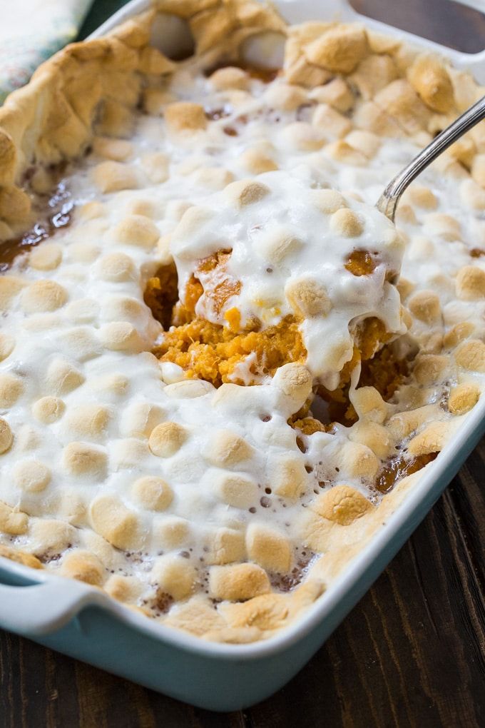 a casserole dish is filled with pudding and whipped cream, on a wooden table