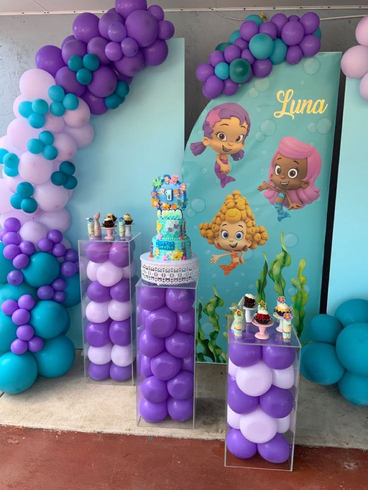 there are many balloons and decorations on the wall for this little mermaid themed birthday party