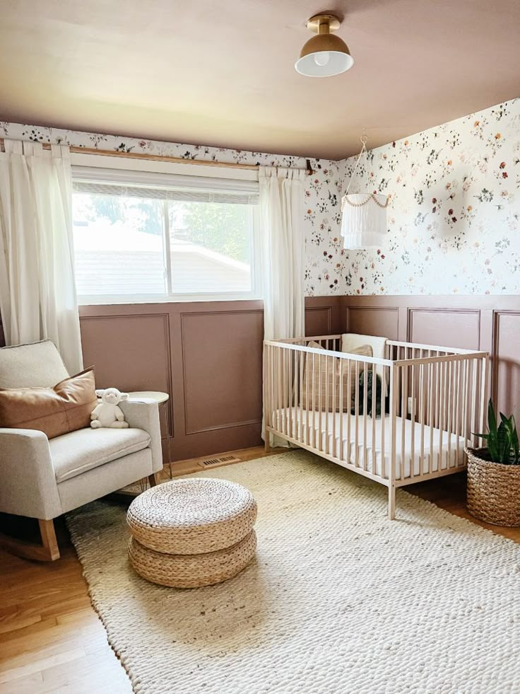 a baby's room with a white crib and floral wallpaper on the walls