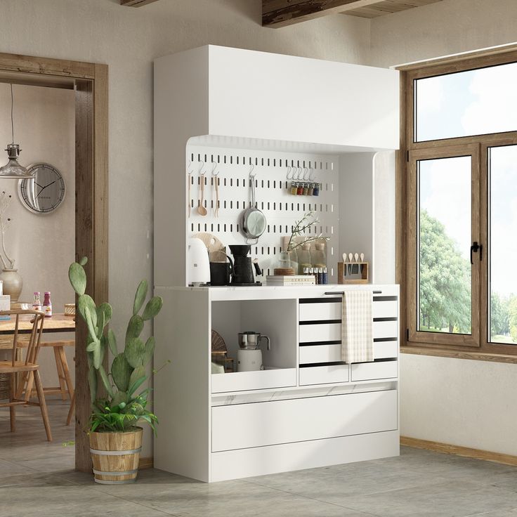 a kitchen with a white cabinet and potted plant next to it on the floor