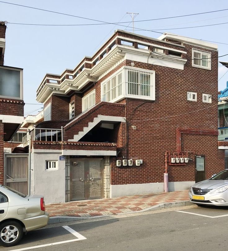 two cars are parked in front of an apartment building