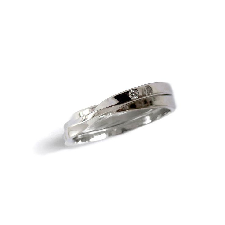 a white gold ring with two diamonds on the top and bottom, sitting against a white background