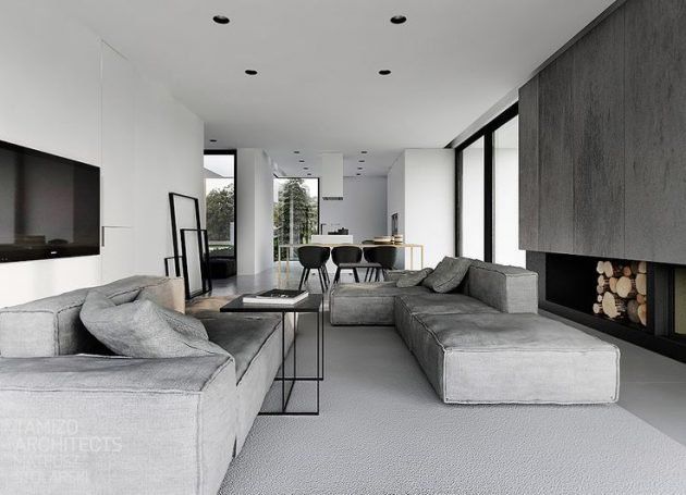 a modern living room with grey couches and fireplace