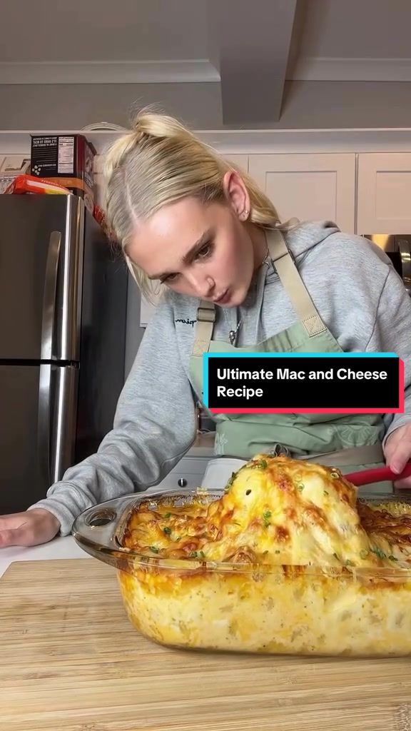 a woman in an apron is looking at a casserole on a cutting board