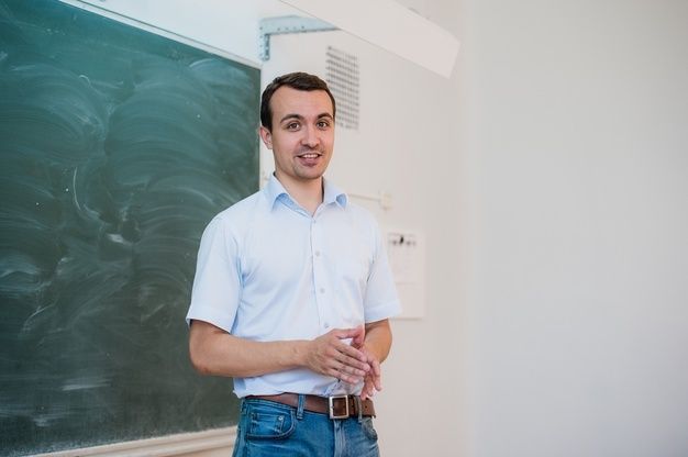 a man standing in front of a chalk board