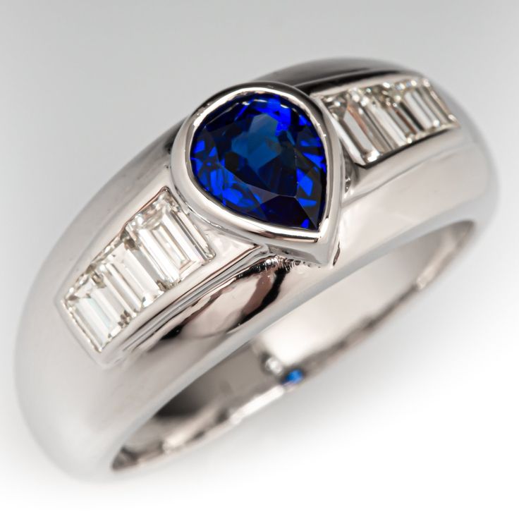 a white gold ring with a blue sapphire and baguettes set in the center