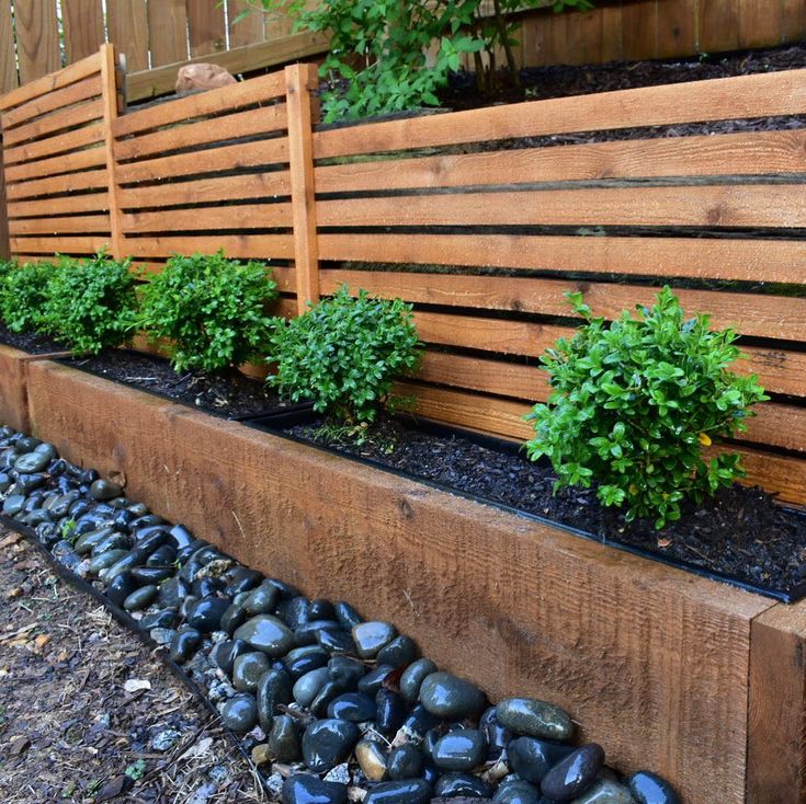 a wooden bench sitting next to a garden filled with lots of rocks and plants on top of it