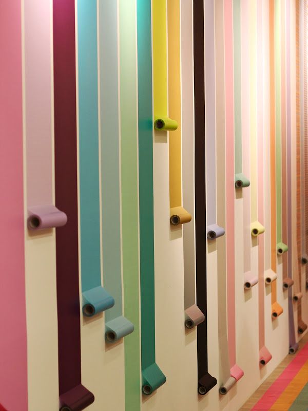 the colorful wall is lined with rolls of toilet paper