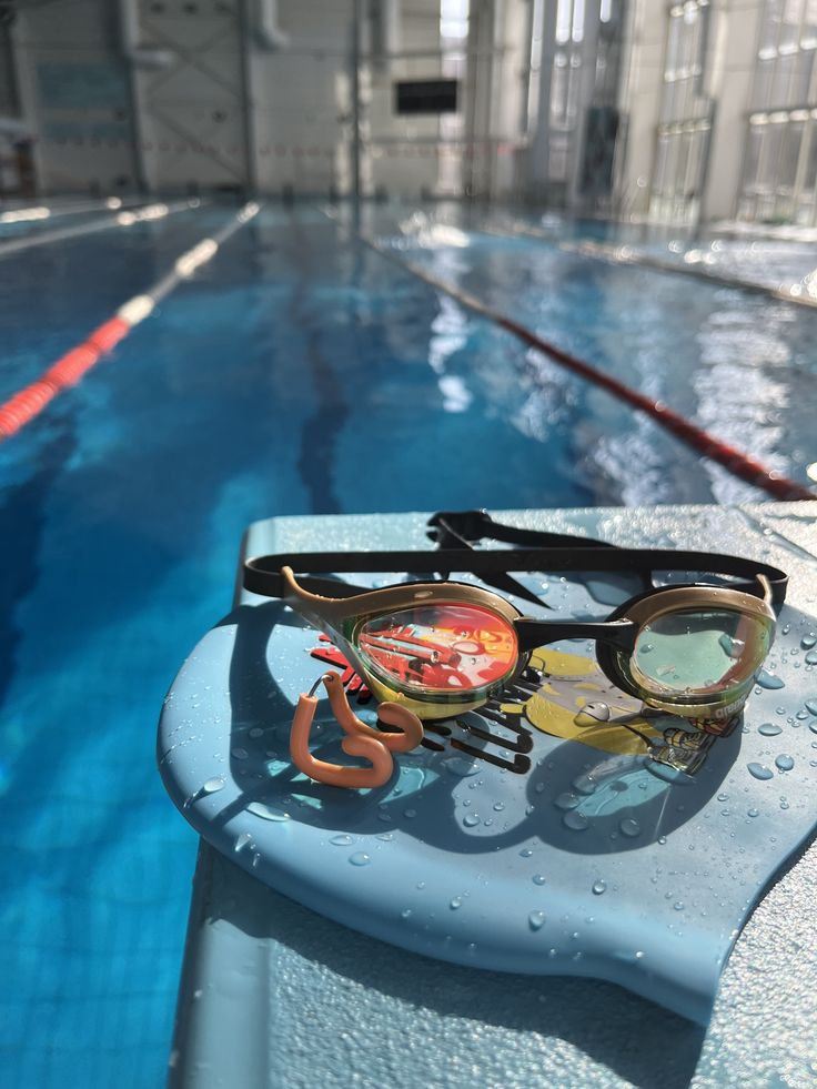 some swimming goggles sitting on the edge of a pool