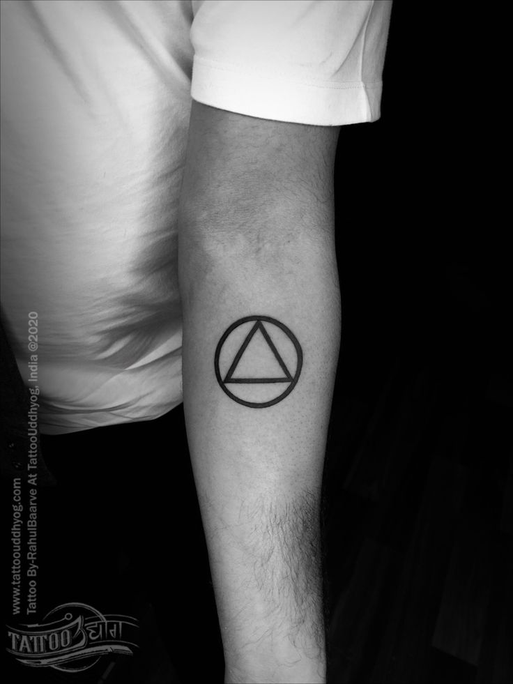 a black and white photo of a man's arm with a triangle tattoo on it