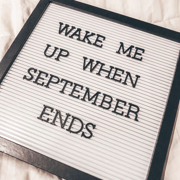 a sign that says wake me up when september ends on a bed with white sheets