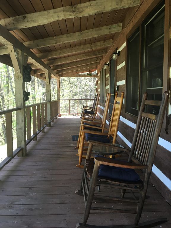 several rocking chairs are lined up on the porch