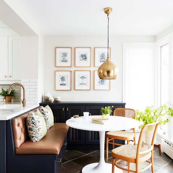 a dining room table and chairs in front of pictures on the wall above it,