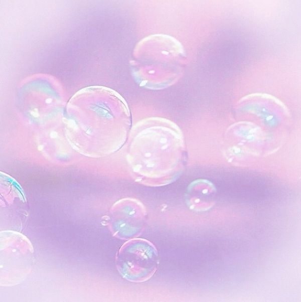 soap bubbles floating in the air on a pink background