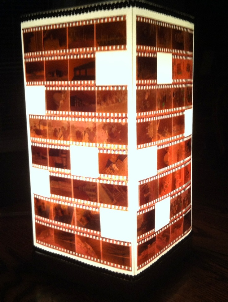 a light that is sitting on top of a wooden table with film strips around it