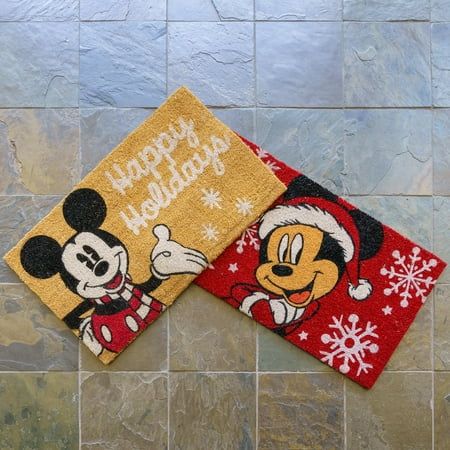 two mickey mouse christmas towels sitting on top of a tile floor