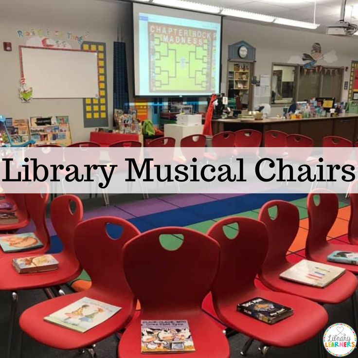 a classroom with red chairs and a projector screen that says library musical chairs on it