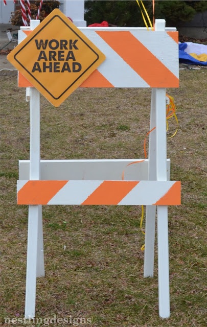 a work area sign sitting in the grass