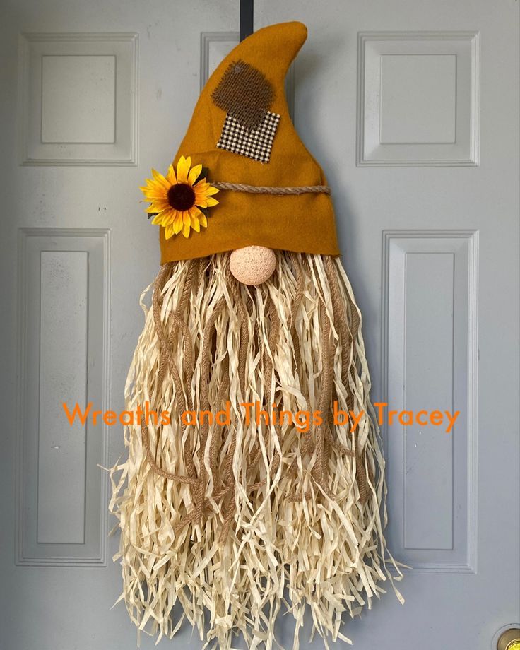 a scarecrow door hanger with a sunflower on it's head and eyes