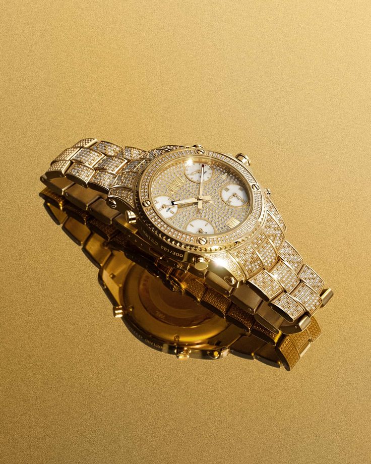 Universal style. Jet Setter PS is designed to explore with five time zone capability, Swiss movements, and 550 diamonds set across the face, bezel, and bracelet, totaling 2.75 carats. The 50 MM case makes a bold statement, finished with ornate details including gold-tinted mother-of-pearl sub dials, the individual production number engraved on the case, and a textured, two-tone bracelet crafted in durable, 18K gold-plated stainless steel. Included with four year Platinum Warranty coverage and an Luxury Diamond Chronograph Watch With Metal Dial, Luxury Gold Diamond Watch With Accents, Luxury Gold Diamond Watch With Diamond Accents, Luxury Watches With Diamond Accents, Luxury Gold Diamond Watch With Subdials, Luxury Jewelry With Diamond Accents And Round Dial, Luxury Gold Diamond Watch With Bling, Luxury Diamond Bling Jewelry And Watches, Luxury Watches With Bling And Cubic Zirconia