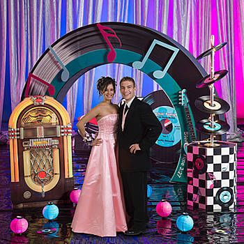 two people standing in front of an old fashioned jukebox and checkered backdrop