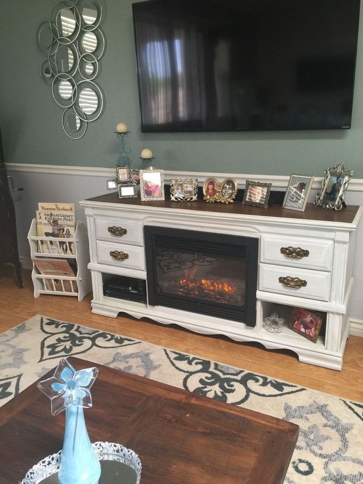 a living room with a fireplace and television on the wall in front of an entertainment center