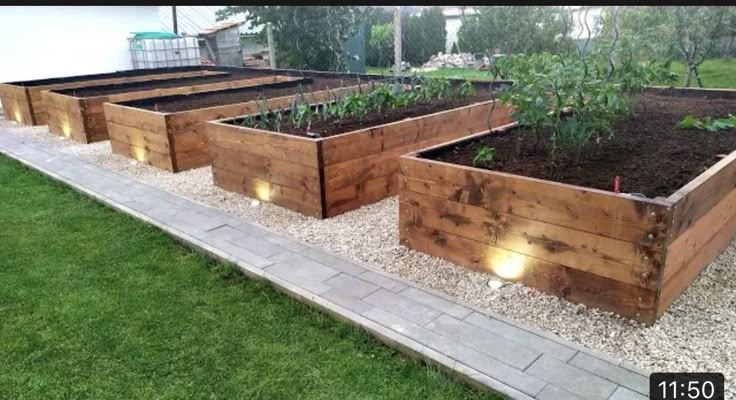 several wooden raised garden beds with lights on them