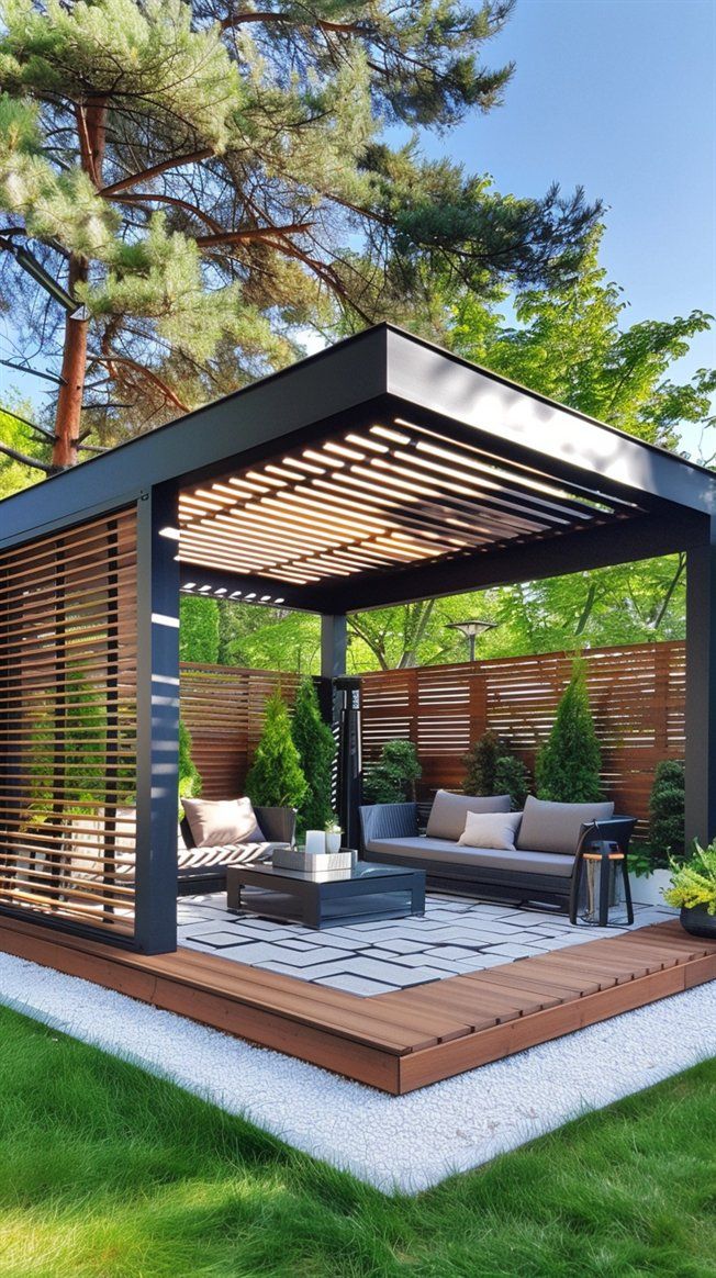 an outdoor living area with couches, tables and chairs in the grass next to trees