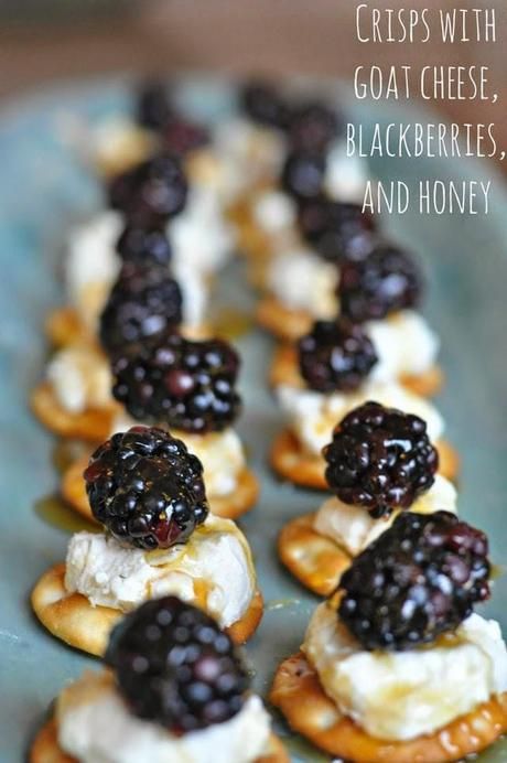 mini crepes with goat cheese, blackberries and honey on a blue plate