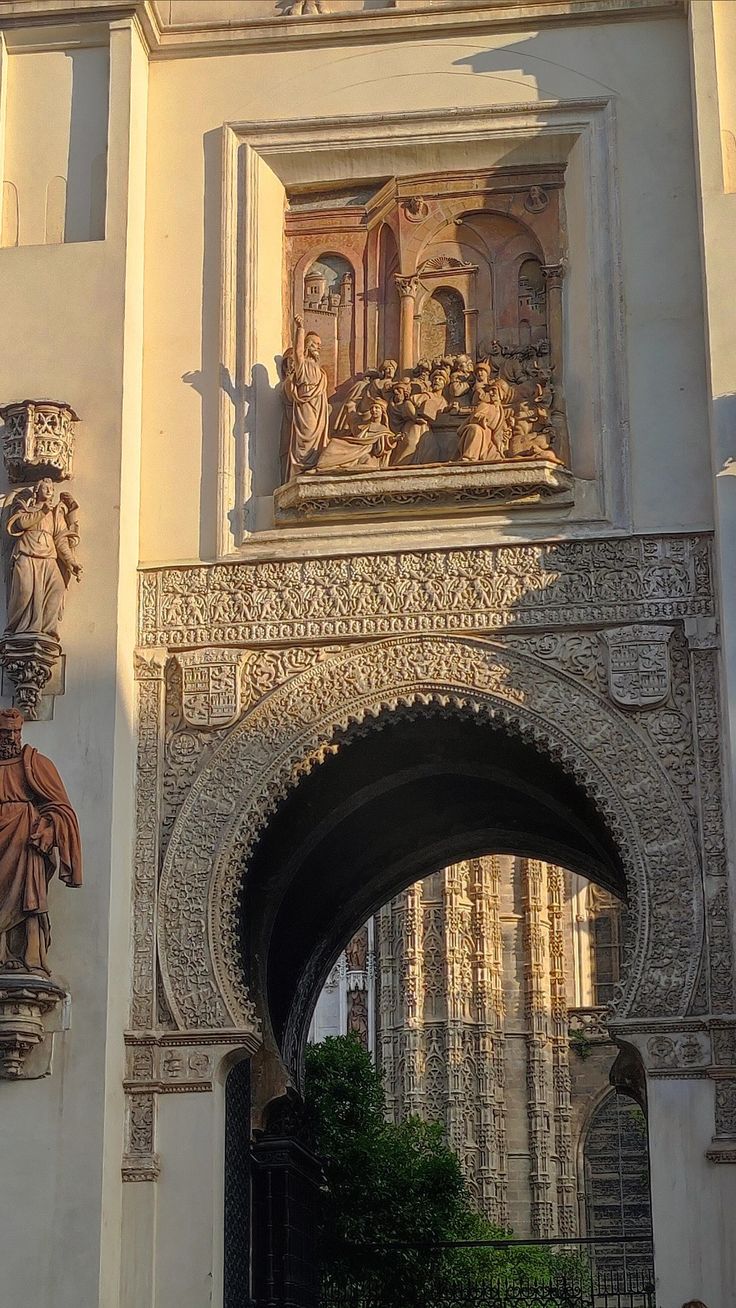 an ornate building with statues on the front and side walls, along with archways