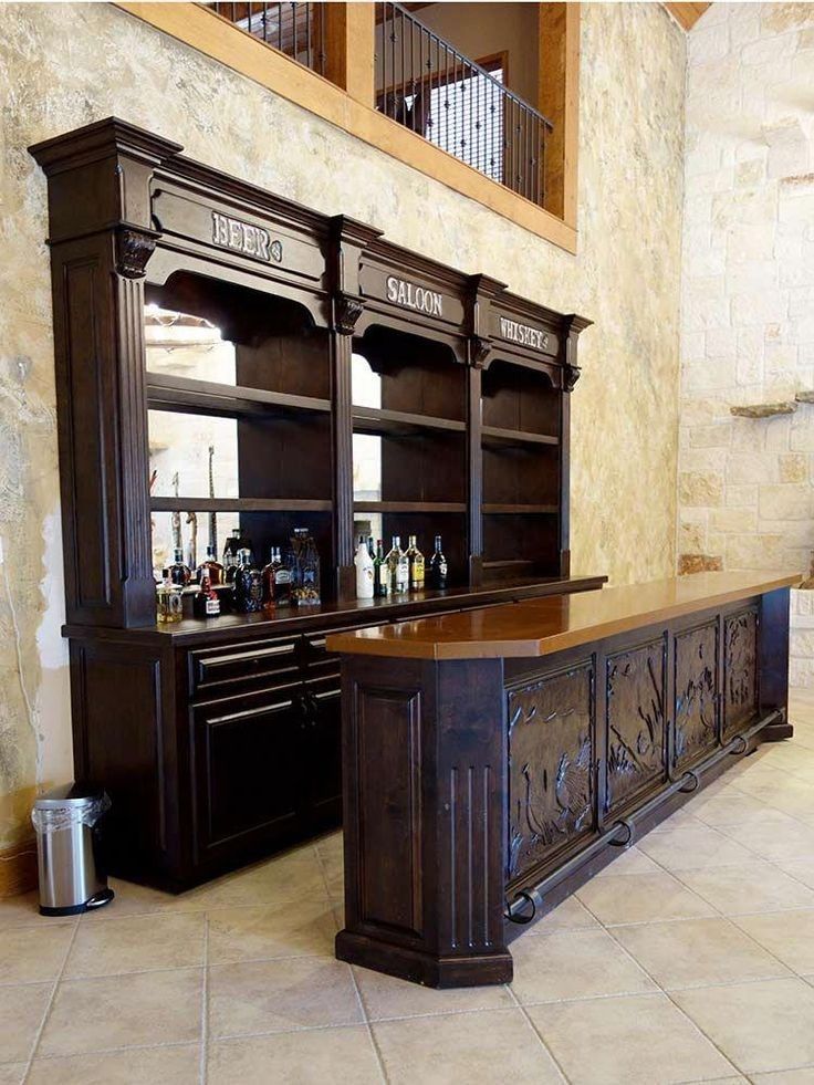 a large wooden bar in the middle of a room next to a wall with shelves on it