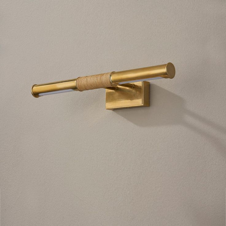 a wall mounted brass toilet paper holder with two rolls on each side and a wooden handle