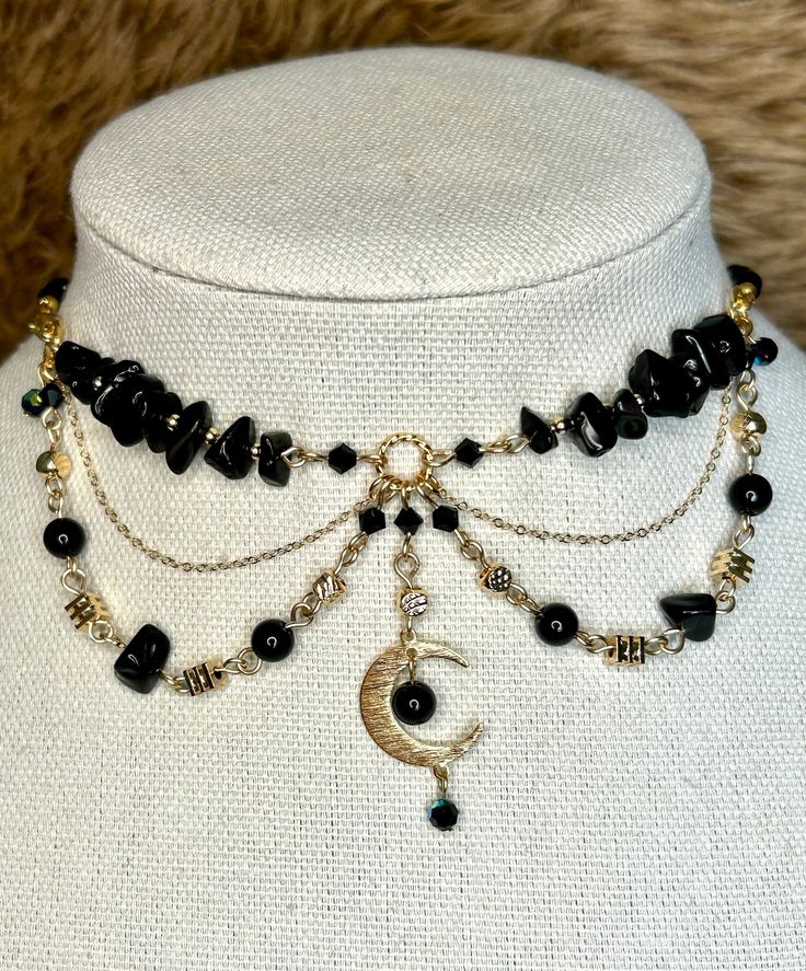 Embrace your inner fairy with this enchanting handmade choker necklace. Crafted with love and attention to detail, this fairy-core inspired piece features stunning black obsidian stones and delicate gold filled metals. The deep black hue of the obsidian stones exudes a mystical and grounding energy, while the gold filled metals add a touch of elegance and sophistication. Each stone is carefully handpicked to create a unique and intricate design that captures the essence of fairy magic. This chok Adjustable Magical Moon Phase Jewelry, Magical Gold Jewelry For Festival, Handmade Magical Black Jewelry, Handmade Black Magical Jewelry, Handmade Fantasy Choker As Gift, Handmade Fantasy Choker For Gifts, Mystical Black Choker Necklace, Black Mystical Choker Necklace, Mystical Moon Charm Jewelry For Festivals