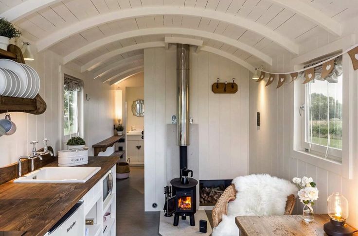 the interior of a tiny home with white walls and wood flooring is lit by lights