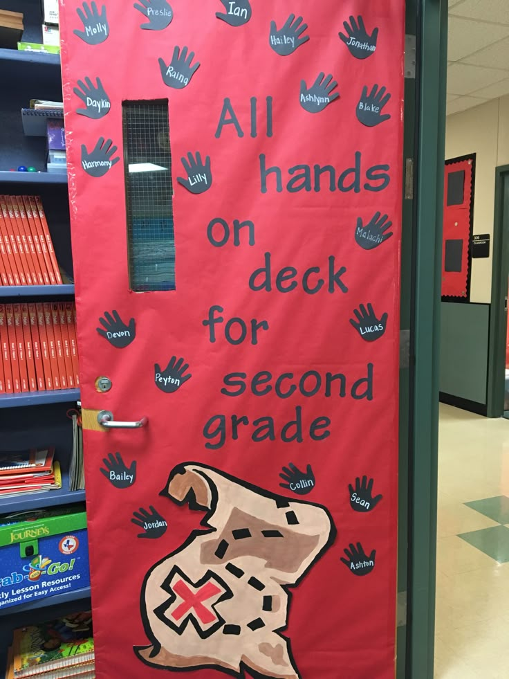 a red door with hand prints on it and the words all hands on deck for second grade