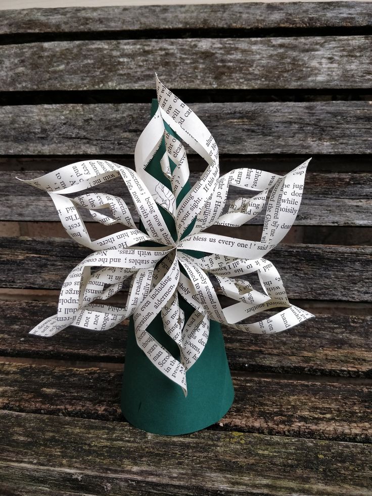 a paper snowflake sitting on top of a wooden bench