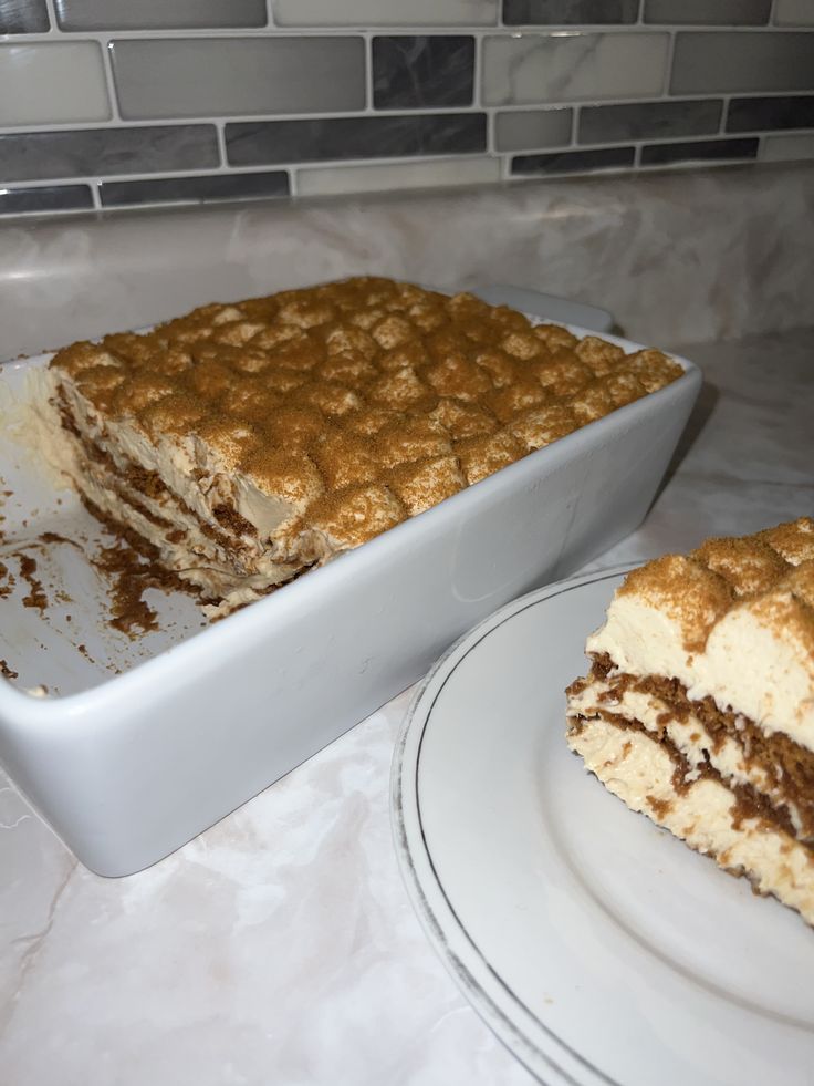 a cake sitting on top of a white plate next to a pan filled with it