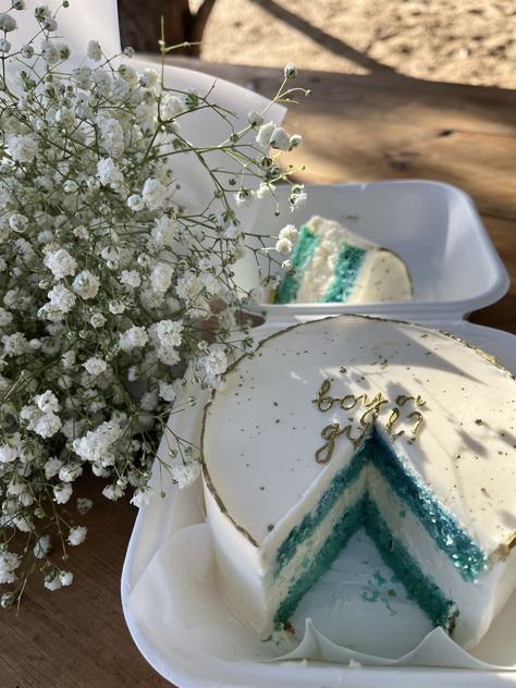 there is a cake with blue and white frosting on the plate next to flowers