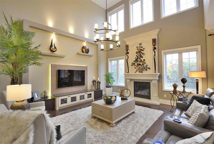 a living room filled with furniture and a flat screen tv mounted on a wall above a fire place