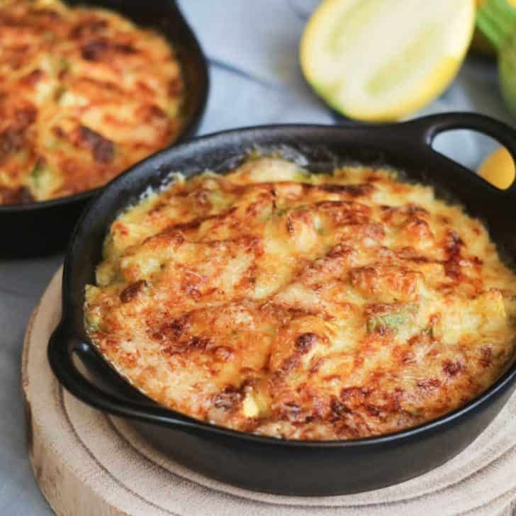 two black pans filled with food sitting on top of a table